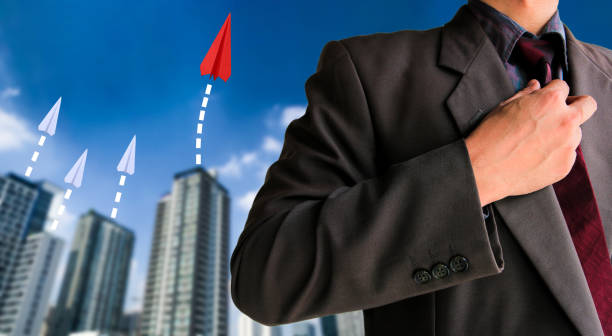 istock Red paper airplane with white other and building background 1130066138