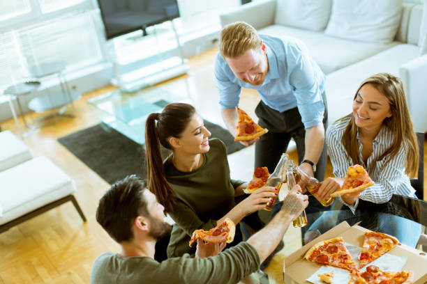 istock Young people eating pizza and drinking cider in the modern interior 1130068041