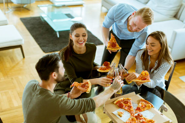 istock Young people eating pizza and drinking cider in the modern interior 1130068043