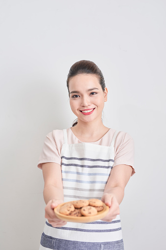 Young woman holding a plate of homemade chocolate cookies