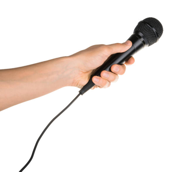 istock Hand holding microphone isolated on white clipping path 1130070485