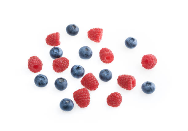 istock Raspberries and blueberries white background top view 1130070533