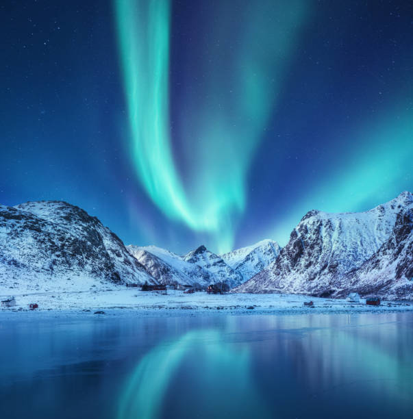aurora boreale sulle isole lofoten, norvegia. verde aurora boreale sopra le montagne. cielo notturno con luci polari. paesaggio notturno invernale con aurora e riflessione sulla superficie dell'acqua. immagine norvegia - star shape sky star aurora borealis foto e immagini stock