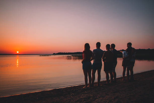 istock Group of beautiful people having fun at sunset beach 1130070689