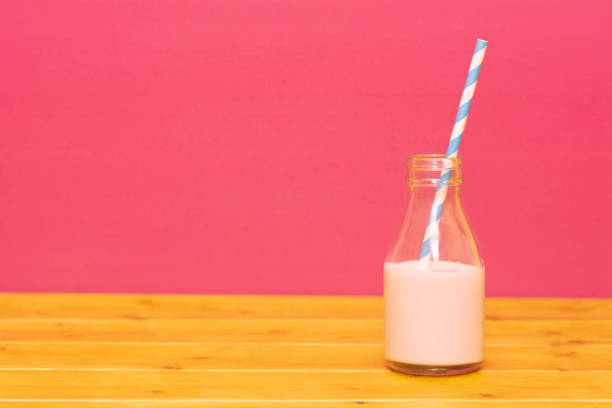 istock Milk bottle half full with strawberry milkshake with a straw 1130071783