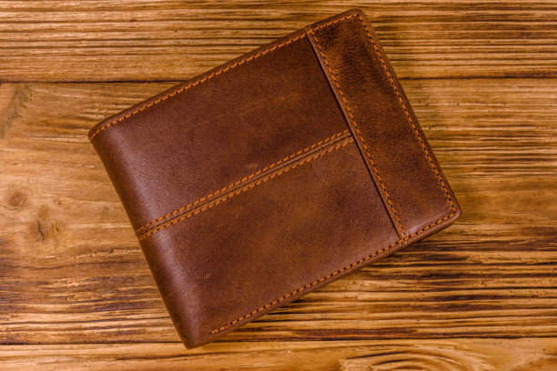 istock Closed brown leather wallet on wooden table. Top view 1130072000