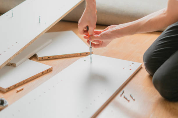 close up man assembling new furniture with a screwdriver b