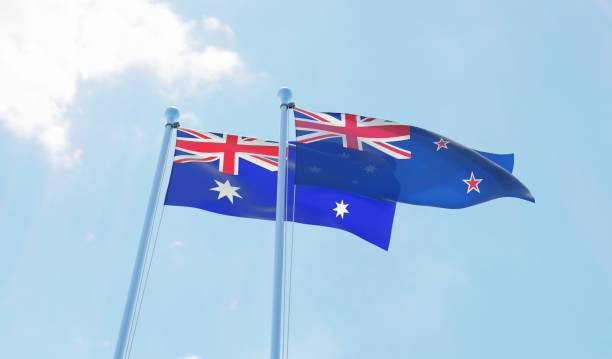 la nouvelle-zélande et l’australie, deux drapeaux agitant contre le ciel bleu - new zealand flag photos photos et images de collection