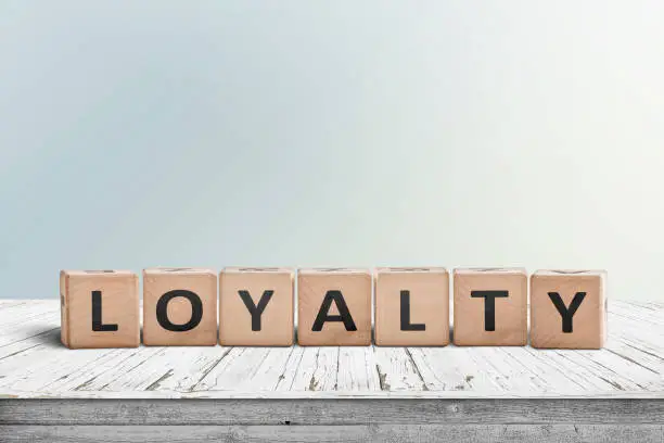Photo of Loyalty sign on a wooden table in bright daylight