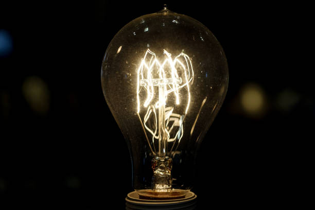 istock old light bulb glowing in dark . Close up 1130082621