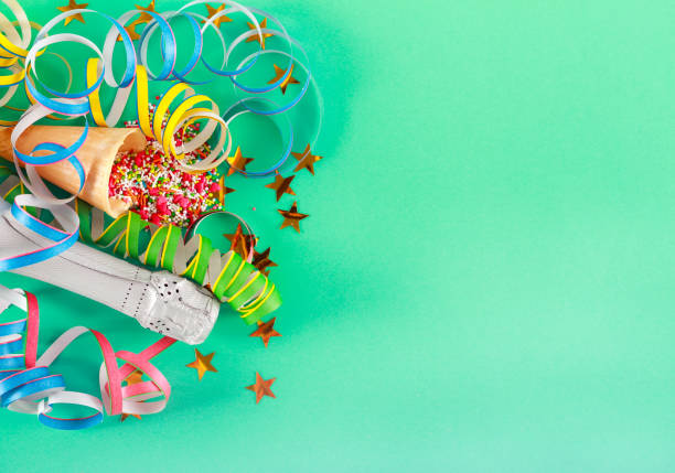 Celebration concept - bottle, sprinkles over green background, copyspace