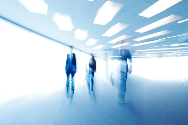 Blurred image of business people walking Blurred image of business people walking together in office defocused office business motion stock pictures, royalty-free photos & images