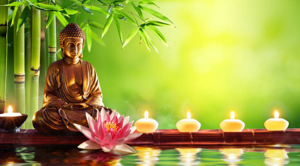 statua del buddha con candele in sfondo naturale - budda foto e immagini stock