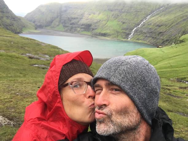 Happy Mature Caucasian Couple In The Remote Landscape Of Saksun, Faroe Islands stock photo