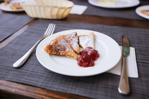 istock Pancakes with jam and powdered sugar on a white plate. Fresh morning aromatic breakfast. 1130097246