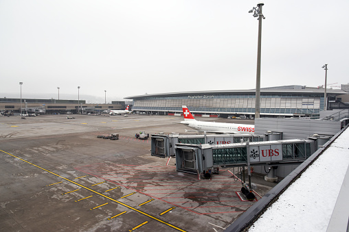 Airport Zurich ZRH with Airfield between the Gates.  The airport is located 13 kilometres outside of the City. Zurich Airport offers scheduled and charter flights to 203 destinations in 67. The Image was captured during winter season.