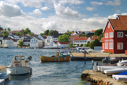 Boats in the harbour of Lillesand, situated on the southern coast of Norway. Characteristic houses around the harbour.