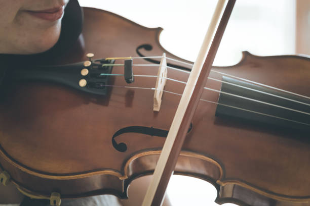 istock Young girl happily plays on her violin 1130099059