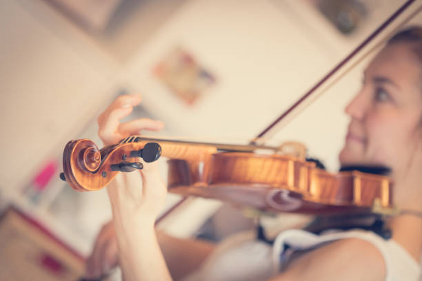 istock Young girl happily plays on her violin 1130099595