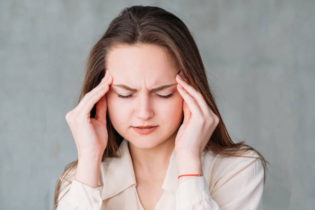 istock young woman portrait stress headache touch temple 1130100524