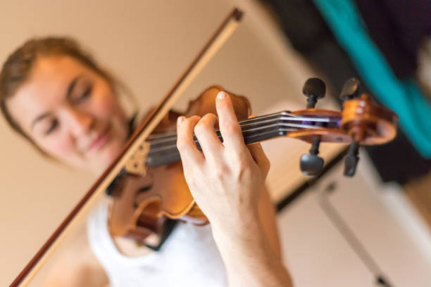 istock Young girl happily plays on her violin 1130100623