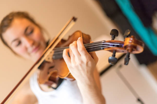 istock Young girl happily plays on her violin 1130100633