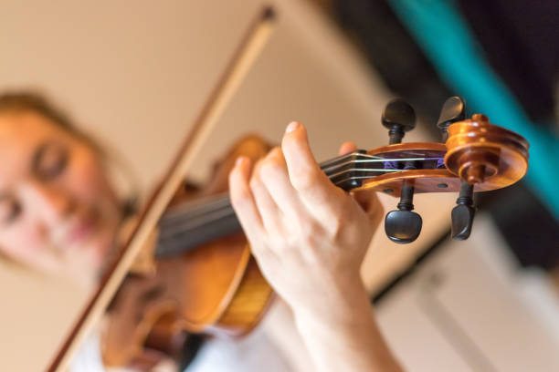 istock Young girl happily plays on her violin 1130100678