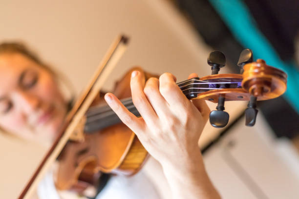 istock Young girl happily plays on her violin 1130100706