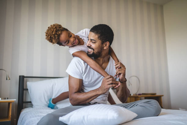 istock Playful father and daughter in bed 1130104852