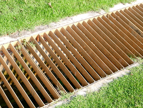drainage hidden on the edge of an asphalt road Drainage system hidden in a perforated concrete gray curb. the water along the entire length of the road drains into the sewer through holes entire, hole, clever, hatch, kerb, perforation , roadway, permeability, seepage, system, slotted