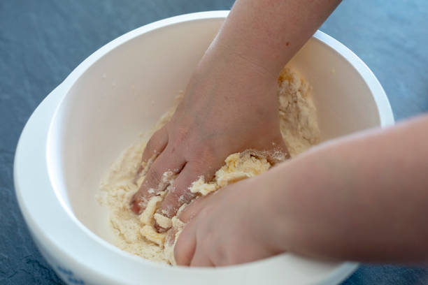 Close up of female hands preparing and knead the dough in bowl