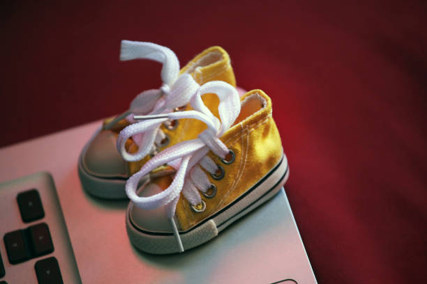 istock yellow sneakers laptop background 1130119566