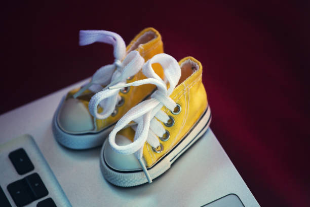 istock yellow sneakers laptop background 1130119567
