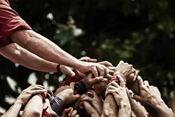 Image of the hands of a group of castellers, that join to support the human castle that they try to do. Version in color