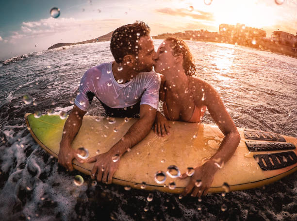 행복 한 로맨틱 커플 바다-물에서 부드러운 순간 데 스포티 한 서퍼 bodyboarding-익 스 트림 스포츠, 사랑, 관계와 건강 한 라이프 스타일 개념에서 서핑 하는 동안 키스 - bodysurfing 뉴스 사진 이미지
