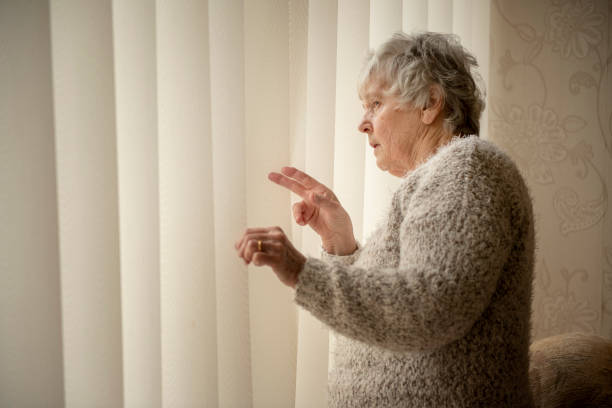 voisin de nosey, femme âgée regardant par la fenêtre - indiscret photos et images de collection