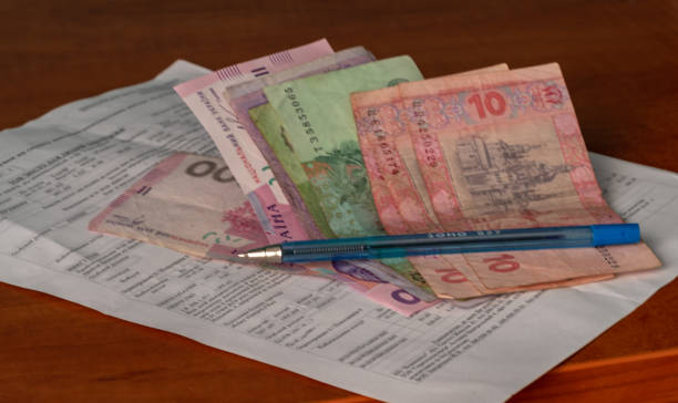 rachunek za media i ukraińskie pieniądze leżące na stole - инвестиции zdjęcia i obrazy z banku zdjęć