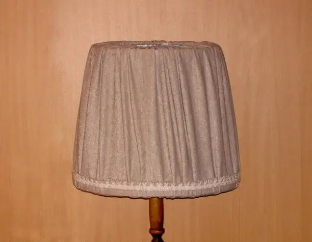 Lamp floor old retro and its upper textile part, on the background wall imitating wood, image