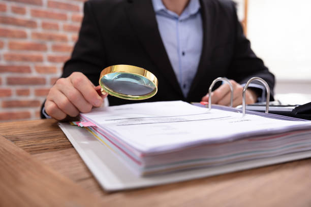 istock Businessman Examining Invoice Through Magnifying Glass 1130134881