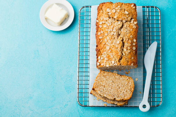 istock Healthy vegan oat, coconut loaf bread, cake on a cooling rack. Blue background. Copy space. Top view. 1130138198
