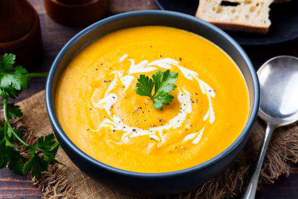 かぼちゃとにんじんのスープ、クリームとパセリの暗い背景の木の tadka。クローズ アップ。 - thanksgiving vegetarian food pumpkin soup ストックフォトと画像