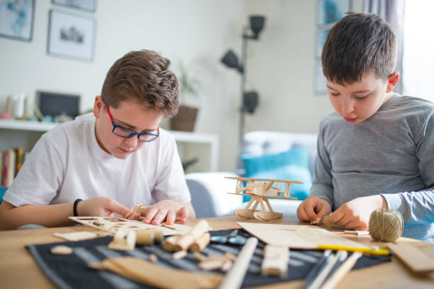 istock Brothers making wooden model plane for school project 1130141816