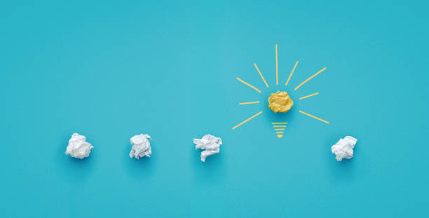 Crumpled paper light bulb over blue background