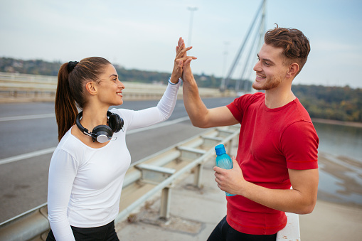 Photo of young couple high five after training