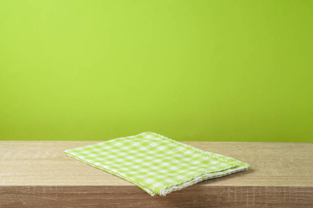 istock Empty wooden table with tablecloth over green wall  background. 1130150668