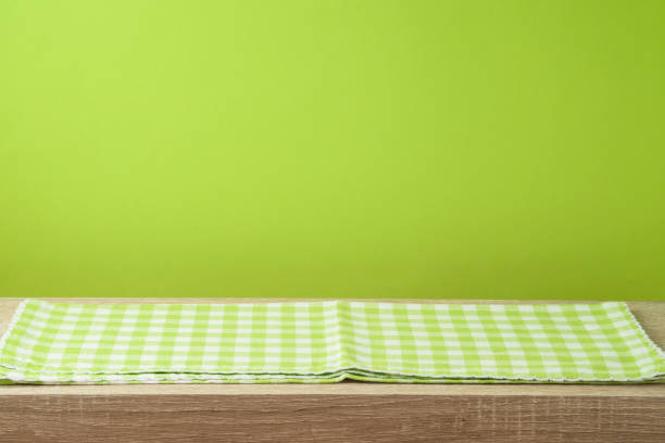 istock Empty wooden table with tablecloth over green wall  background. 1130150685