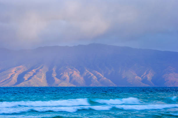 Sea waves beneath a quilt of fluffy clouds on a sunlit day, blending tranquility and awe-inspiring nature, California