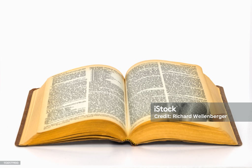 Open bible on plain white background with yellowed pages Open bible on plain white background with yellowed pages and small text Bible Stock Photo