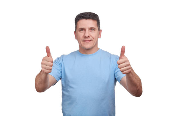 istock Handsome middle-aged man with a slight smile, showing thumbs up with two hands. 1130176272