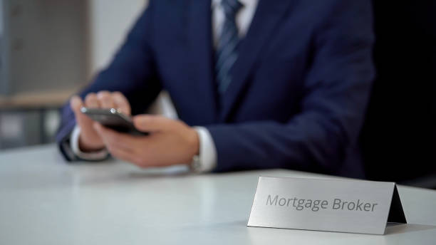 A nameplate that says mortgage broker with a person on the background